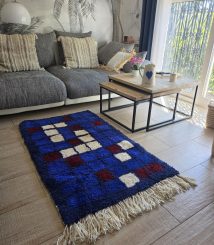 Tapis berbère bleu à carreaux bordeaux et écru dans un salon