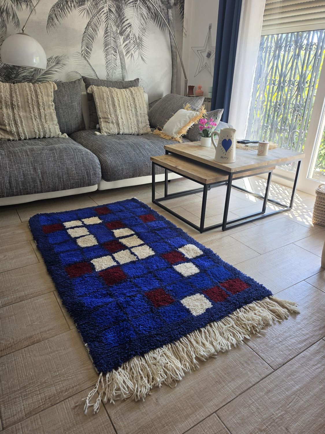 Tapis berbère bleu à carreaux bordeaux et écru dans un salon Tapis berbère bleu à carreaux bordeaux et écru dans un salon