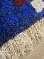 Laine bleue et franges écrues du tapis berbère