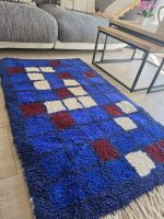 Carreaux bleu, bordeaux et écru du tapis berbère en laine