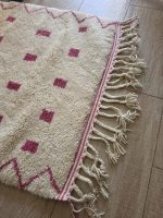 Franges tressées et bande rose du tapis berbère